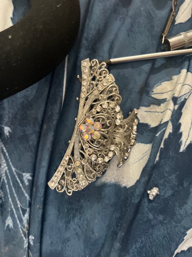 Silver-tone articulated filigree bracelet with clear and aurora-borealis rhinestones; likely base-metal costume jewelry with simulated stones - AI says Fake